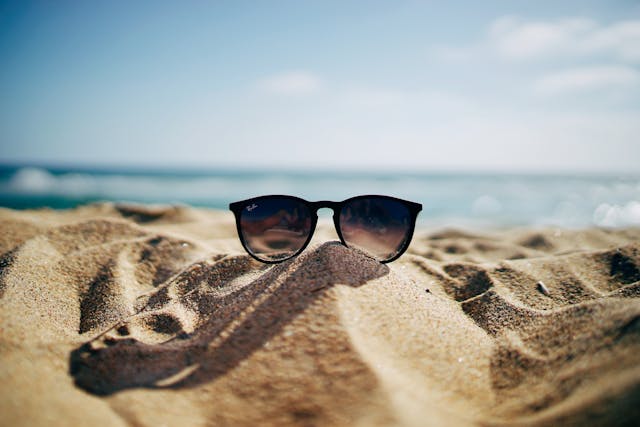 sunglasses on the beach with sea in the background photo.