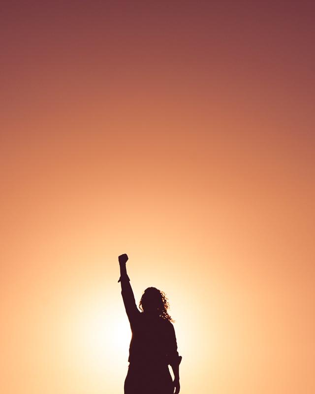 silhouette of a woman raising her arms.