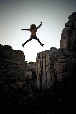 a woman jumping off a cliff.